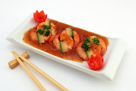 shrimp with sauce in rectangular white ceramic tray and pair of brown chopsticks thumbnail