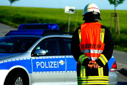 man wearing white helmet standing near blue and white police mobile thumbnail