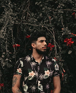 man standing in front of flower plant thumbnail