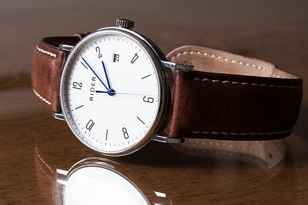 round silver-colored analog watch with brown leather strap on brown wooden surface thumbnail