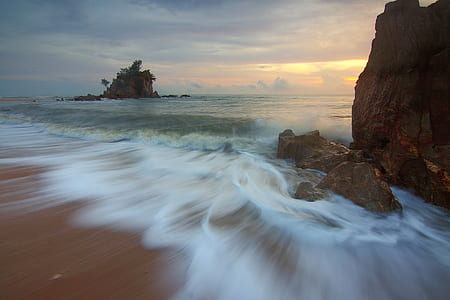 brown rock beside body of water thumbnail