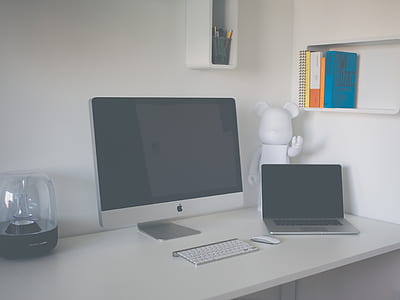 silver iMac, Apple Wireless Keyboard, and MacBook Pro on desk thumbnail