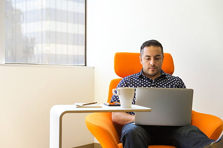 man in collared top seating on yellow armchair thumbnail