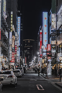 people walking near signs and parked cars during nighttime thumbnail