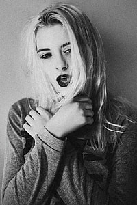 grayscale photography of a woman posing against wall thumbnail