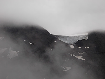 black mountain filled with snow and fog thumbnail