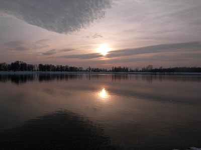 silhouette of trees near body of water during sunset thumbnail