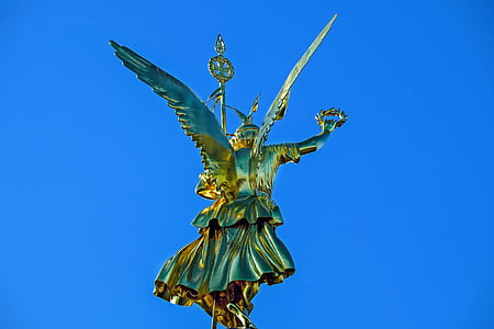 photo of gold-colored statue under blue sky at daytime thumbnail