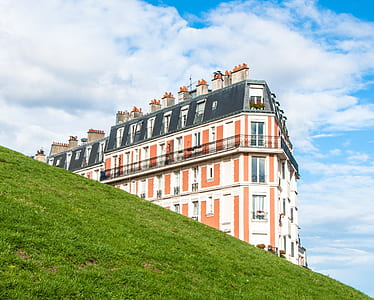 white and orange building near hill thumbnail