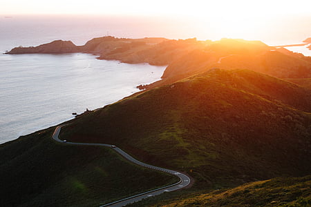 seaside hills with road during sunrise thumbnail