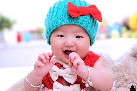 baby wearing red top and blue knit cap thumbnail