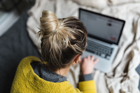 Blond using her laptop at her bedroom thumbnail