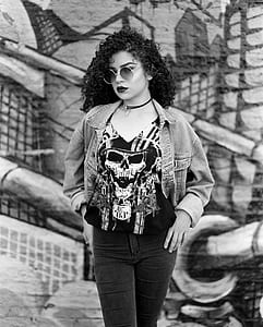 grayscale photo of woman standing in front of wall thumbnail