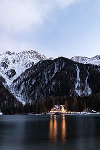 house on snowy forest near at body of water thumbnail