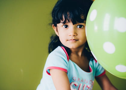 girl wearing teal shirt near green and white polka-dot balloon thumbnail