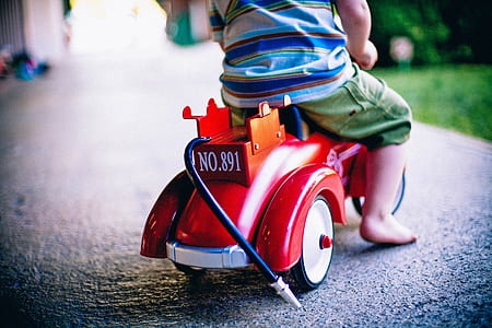 toddler riding red and orange ride on toy thumbnail