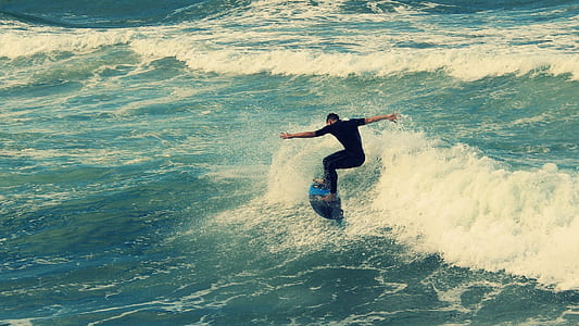 man surfing on large body of water thumbnail