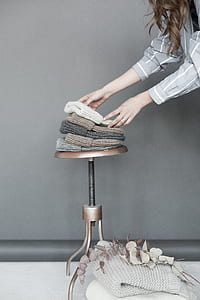 Woman Staking Five Assorted Color Beanies on Brown Steel Stool thumbnail