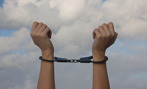 person wearing black handcuffs thumbnail