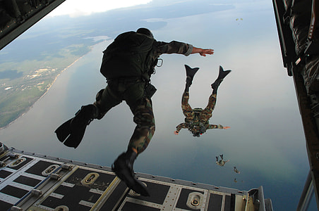 man ready to jump from plane to body of water with parachute thumbnail