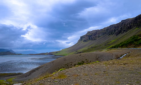 Mountains Near Water Under Cloudy Day Sky thumbnail