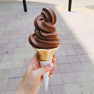 person holding chocolate ice cream with cone thumbnail