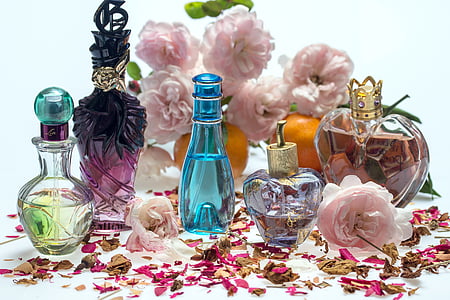 blue fragrance glass bottle beside clear fragrance bottle thumbnail