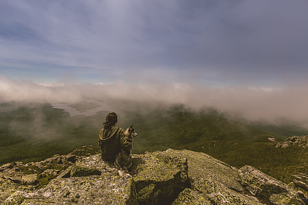 person sits on rock mountain peak thumbnail