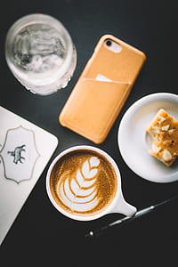 flat-way photography of latte on cup beside iPhone and cookie thumbnail