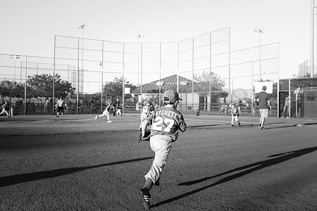 grayscale photography of boy playing baseball at daytime thumbnail