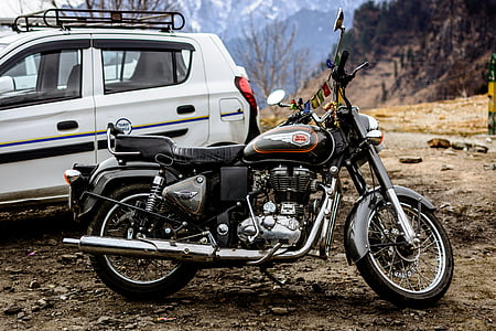 black standard motorcycle near white SUV thumbnail