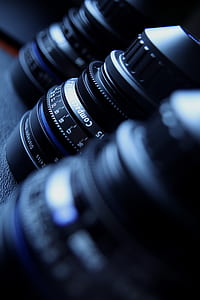 three black camera zoom lenses on black surface thumbnail