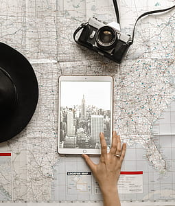 person using gold iPad beside black and gray camera thumbnail