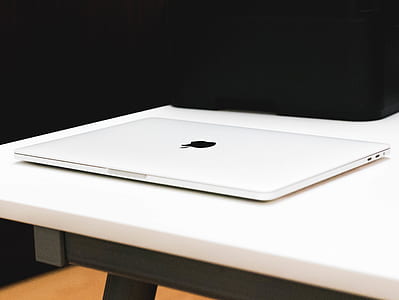 closed white MacBook on top of white table thumbnail