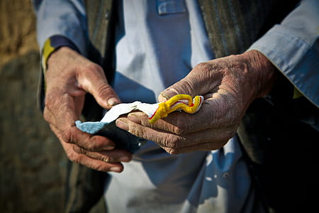 close-up photo of person holding white and brown textile thumbnail