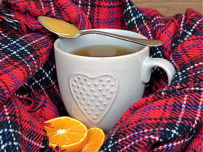 stainless steel spoon on top of white ceramic mug beside sliced orange fruit thumbnail