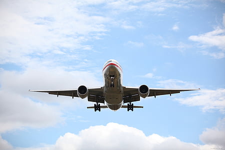 gray and red airplane at clear blue sky thumbnail