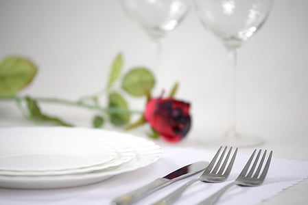 three round white ceramic plates near silver bread knife and two forks thumbnail