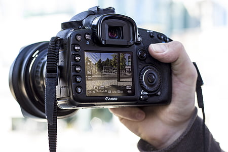 person holding black Canon DSLR camera thumbnail