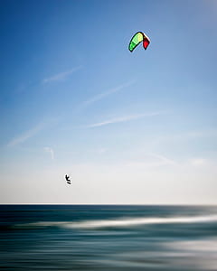 silhouette photo of person kite boarding during daytime thumbnail