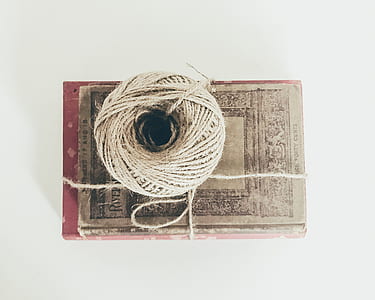 beige tie on top of brown and red book thumbnail