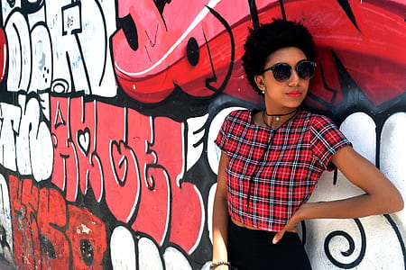 woman standing in front of white and red wall with graffiti thumbnail