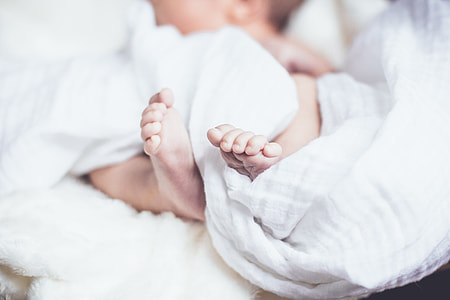 baby covered with white blanket thumbnail