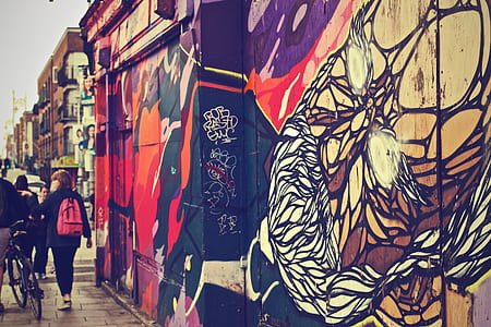 person carrying pink and black backpack walking on street during daytime thumbnail