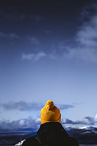 man wearing yellow bobble hat and black jacket thumbnail