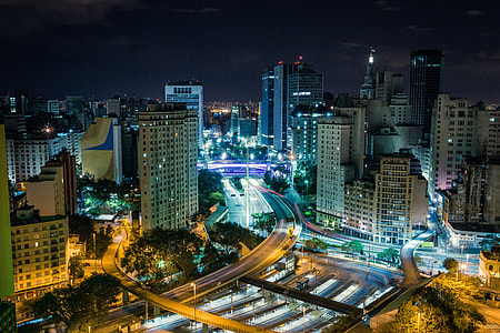 time lapse photo of high rise buildings and cars in city during nighttime thumbnail