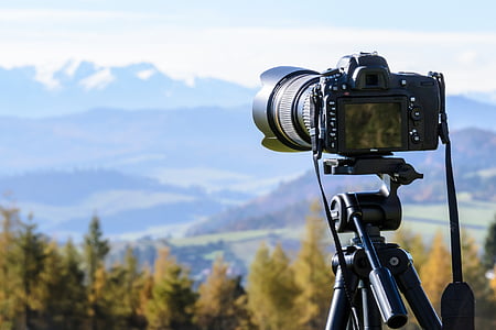 black DSLR camera in black tripod taking shot of mountains during daytime thumbnail