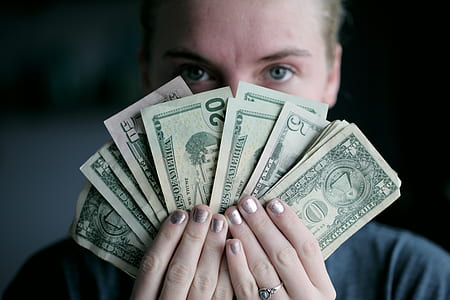 person holding fan of U.S. dollar banknotes thumbnail