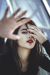 woman wearing black long-sleeved shirt raising hands towards camera thumbnail