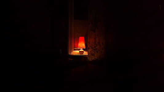 orange table lamp lit inside the dark room thumbnail